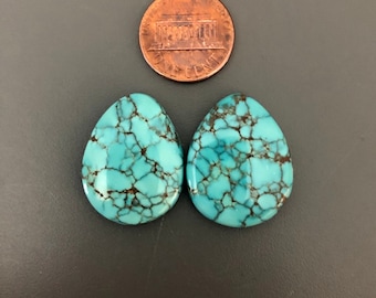 May include: Pair of turquoise cabochons in a teardrop shape with a brown matrix. The stones are approximately the size of a US penny.