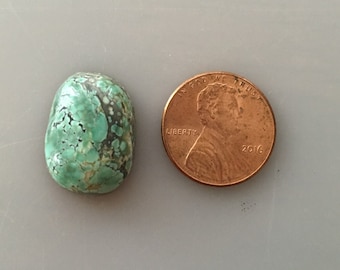 May include: A green turquoise cabochon stone, approximately the size of a US penny.