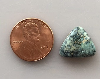 May include: A triangular turquoise cabochon with a green and white marbled pattern. The cabochon is approximately the size of a US penny.