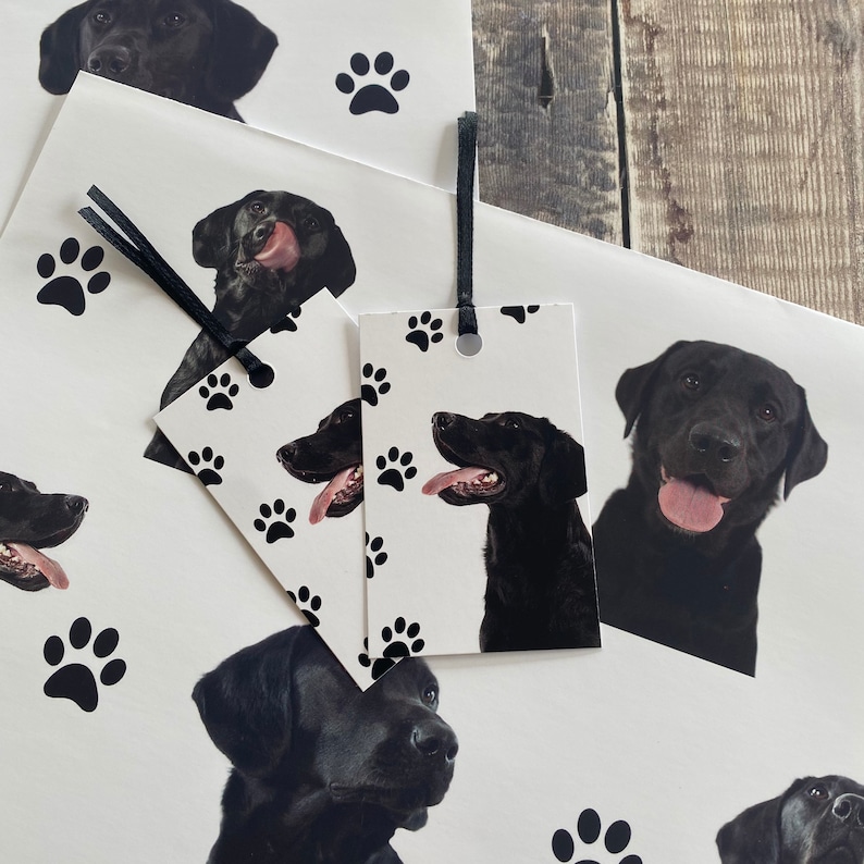 May include: Black and white gift wrap with a black Labrador Retriever dog design. The wrapping paper features paw prints and a gift tag with a black Labrador Retriever dog.