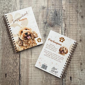 May include: Two spiral-bound notebooks featuring a Cockapoo dog. One notebook displays "Impawtant Notes" and a paw print. The other notebook has breed information and a paw print.