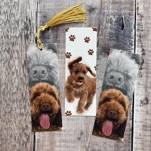 Può includere: Tre segnalibri a tema cane con un cane marrone, un cane bianco e nero e un cane marrone con impronte di zampe. I segnalibri hanno il testo "You Pawed Here".