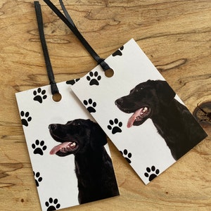 May include: Two black and white gift tags with a black Labrador Retriever on each. The tags have a paw print pattern and black ribbon.