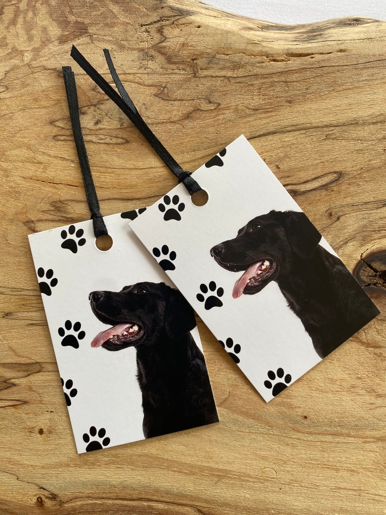 May include: Two black and white gift tags with a black Labrador Retriever on each. The tags have a paw print pattern and black ribbon.