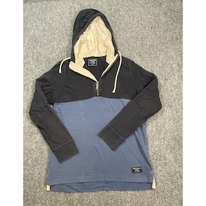 May include: A long-sleeve pullover hoodie featuring a color-blocked design with a dark navy upper section and a muted blue lower section. It includes a cream-colored hood lining, a quarter-zip front closure with cream drawstrings, and an Abercrombie & Fitch label.