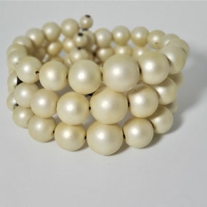 May include: A white pearl bracelet made of multiple strands of pearls.