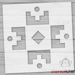 May include: White stencil with a geometric design featuring a diamond shape in the center and four squares with circles at the corners. The stencil is on a wood background.