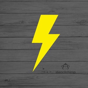 May include: A yellow lightning bolt stencil on a gray wood background. The stencil is for crafting and decorating.