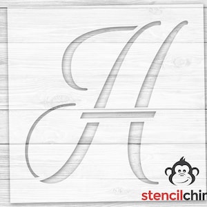 May include: A white stencil of the letter H in a cursive font. The stencil is on a white wood background. The stencil is for use with paint or other mediums to create a decorative design.
