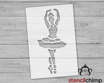 May include: A white stencil of a ballerina in a tutu, with arms raised above her head. The stencil is on a wood background.