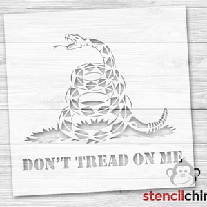 May include: A stencil of a coiled rattlesnake with the words "Don't Tread On Me" underneath. The stencil is designed for use with paint or other mediums to create a decorative design.