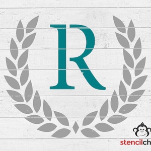 May include: Teal letter R surrounded by a gray laurel wreath on a white wood background.