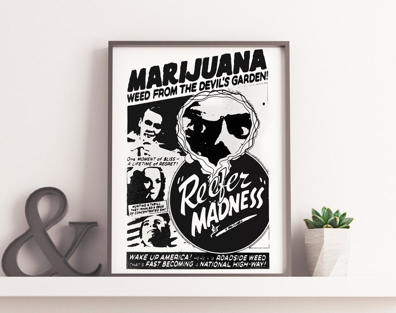 Puede incluir: P&oacute;ster en blanco y negro con el texto "Marijuana Weed from the Devil's Garden!" y "Reefer Madness" en un c&iacute;rculo. El p&oacute;ster presenta a un hombre con gafas de sol y un cigarrillo.