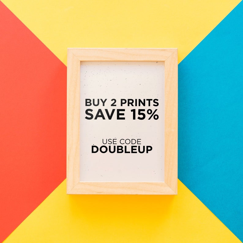 May include: A light wooden picture frame with the text "BUY 2 PRINTS SAVE 15% USE CODE DOUBLEUP" on a white background. The frame is set against a background of red, yellow, and blue geometric shapes.