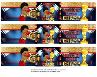 May include: Three printable labels featuring a cartoon illustration of a baby boy wearing boxing gloves and a championship belt. The labels are blue, red, and gold with the text "Welcome Little Champ" and a gold trophy.