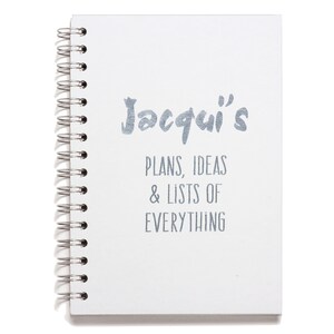 May include: White spiral bound notebook with the text "Jacqui's Plans, Ideas & Lists of Everything" printed in silver on the front cover.