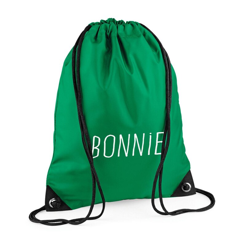 May include: A green drawstring bag with the name "BONNIE" printed in white. The bag has black drawstrings and reinforced corners. This bag is suitable for carrying gym clothes, books, or other items.