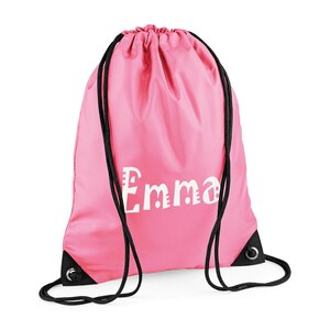 May include: A pink drawstring backpack with the name "Emma" printed in white. The bag has black drawstrings and black reinforced corners. The bag is made of a smooth, possibly nylon, material.