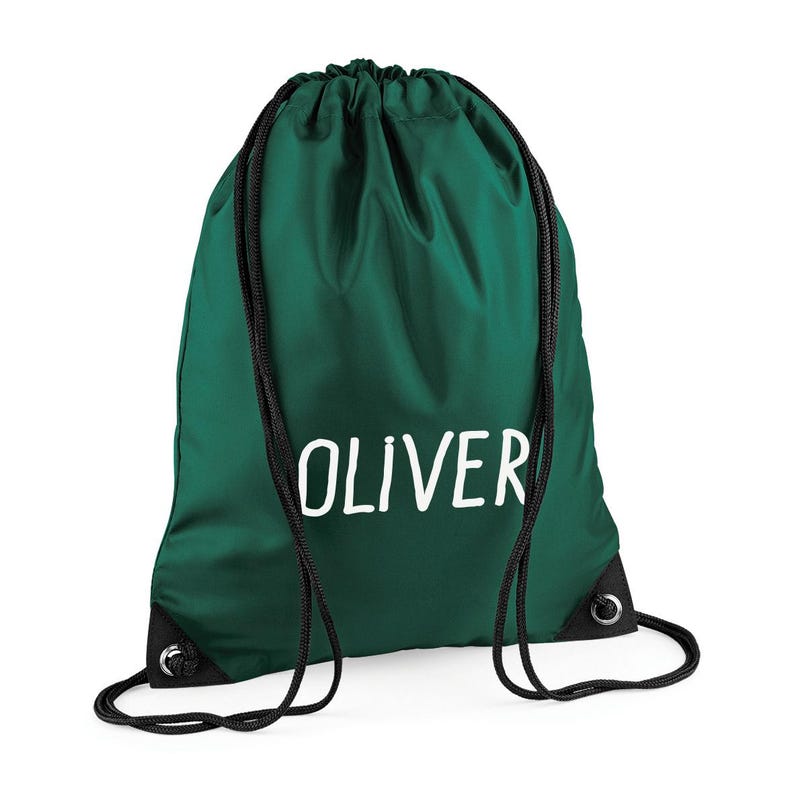 May include: A dark green drawstring backpack with the name "OLIVER" printed in white. The bag has black drawstrings and reinforced corners. This bag is suitable for carrying books, sports gear, or other personal items.