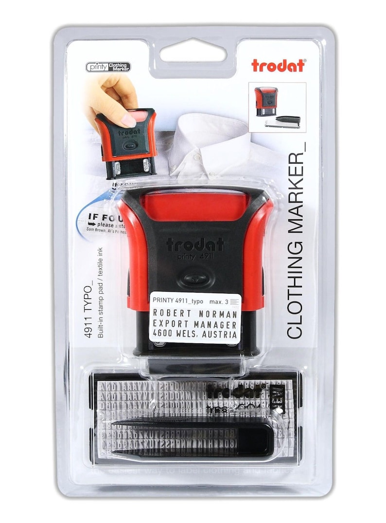 K&ouml;nnte beinhalten: Ein roter und schwarzer Stempel mit Selbsttinte mit dem Text "trodat printy 4911" und "ROBERT NORMAN EXPORT MANAGER 4600 WELS. AUSTRIA". Der Stempel ist in einer durchsichtigen Kunststoff-Klappverpackung verpackt, auf der der Text "CLOTHING MARKER_" aufgedruckt ist.