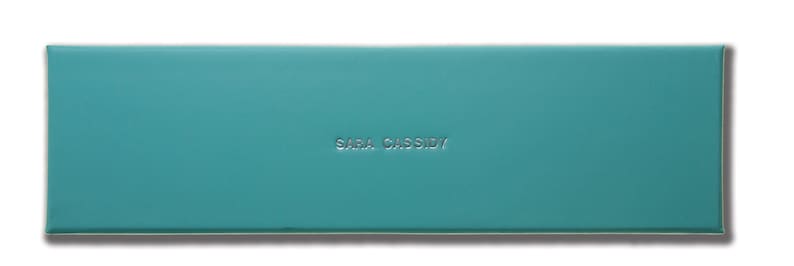 May include: A teal blue box with the text "Sara Cassidy" embossed in silver lettering.