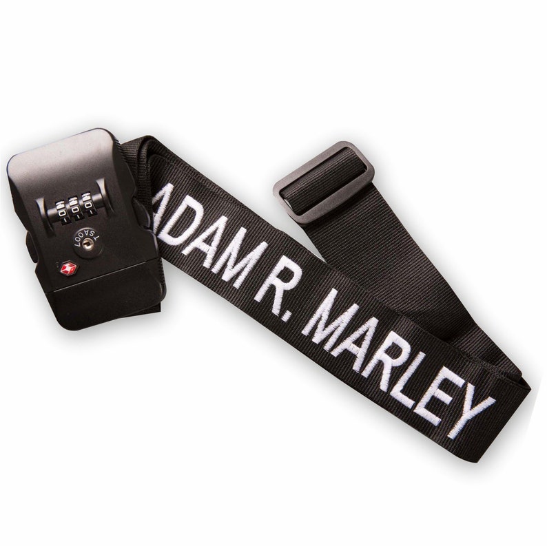 May include: Black luggage strap with a combination lock and the text "ADAM R. MARLEY" in white.