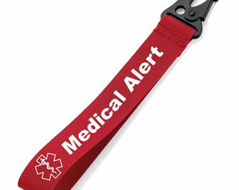 May include: A red medical alert strap with white text reading "Medical Alert" and a white medical symbol. The strap has a black metal clip for attachment.