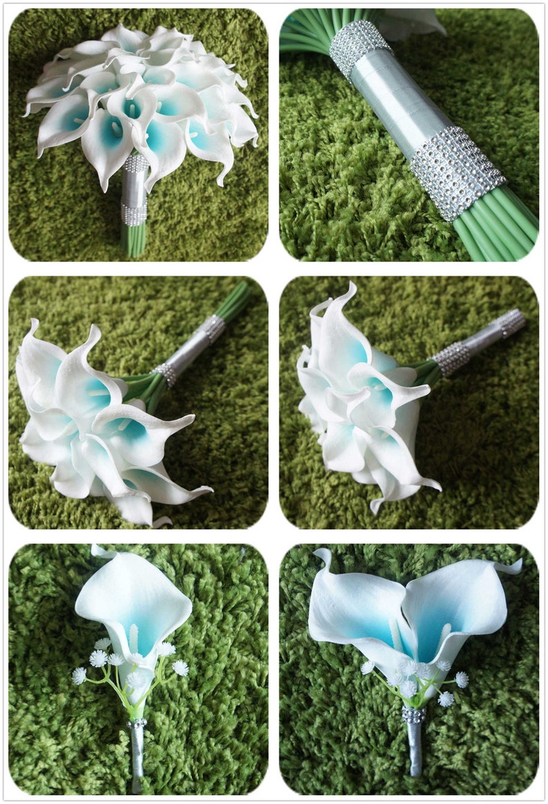 May include: A bridal bouquet of white calla lilies with blue centers. The bouquet is wrapped in a silver ribbon with rhinestones. There is also a matching boutonniere with a single white calla lily with a blue center.
