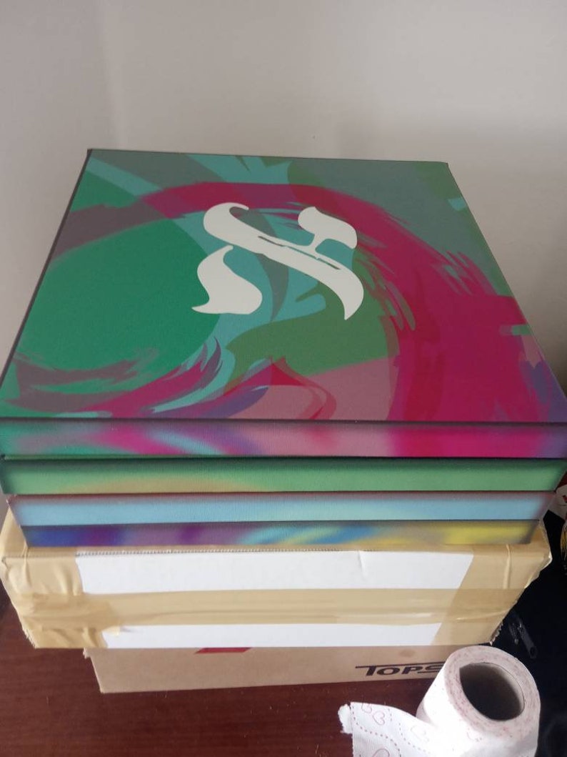 May include: A stack of four canvases with abstract paintings in shades of green, blue, pink, and purple. The top canvas features a white stylized letter "S" in the center.