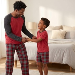 May include: Matching pajama sets featuring red heathered shirts with dark gray raglan sleeves and red and gray plaid pants or shorts. The shirts have a crew neckline, and the bottoms feature a classic tartan pattern in a soft, comfortable fabric.