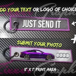 May include: Purple and gray key chain with a black metal ring. The key chain has a white background with the text "JUST SEND IT" and a purple border. The bottom part of the key chain has a photo of a purple Audi car with the Audi logo. The text "SUBMIT YOUR PHOTO" is above the car and the text "5" x 1" PRINT AREA" is below the car.