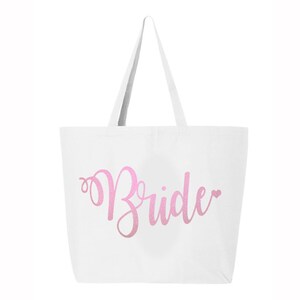 May include: White canvas tote bag with a pink glitter design that says "Bride" with a small heart.