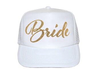 May include: White trucker hat with a gold glitter "Bride" inscription.