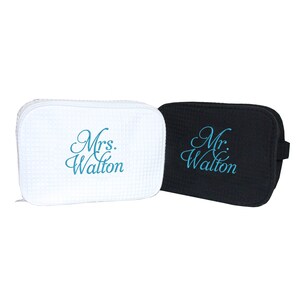 May include: Two toiletry bags, one white and one black, with the words "Mrs. Walton" and "Mr. Walton" embroidered in blue.
