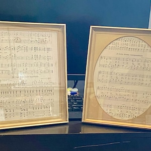 May include: Two framed pieces of sheet music with gold frames. The sheet music is printed in black ink on white paper. The music is for a song called "I've Been Working on the Railroad".