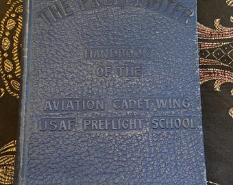 May include: A blue hardcover book titled "The Preflighter Handbook of the Aviation Cadet Wing USAF Preflight School".