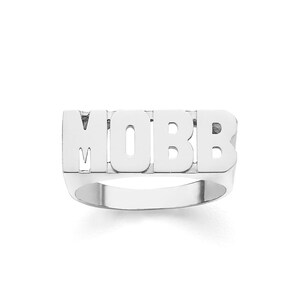 May include: A silver ring with the word "MOBB" spelled out in block letters.