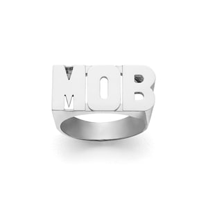 Op de afbeelding: Een zilveren ring met het woord "MOB" in grote, gedurfde letters.
