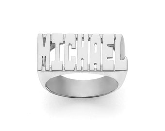 Könnte beinhalten: Ein silberner Ring mit dem Namen "MICHAEL" in einer fetten, klobigen Schriftart graviert.