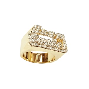 May include: A gold ring with the word "LOVE" spelled out in diamonds.