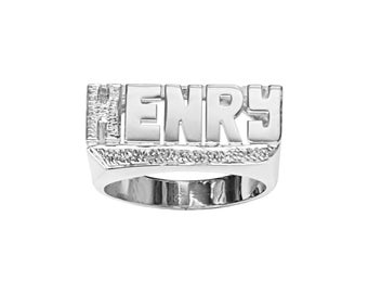 Könnte beinhalten: Ein silberner Ring mit dem Namen "HENRY" eingraviert. Der Ring hat eine strukturierte Band und eine erhabene, rechteckige Namensschilder.