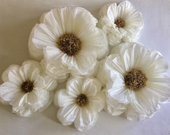 May include: A set of six large white paper flowers with brown centers. The flowers are arranged in a cluster on a white background.
