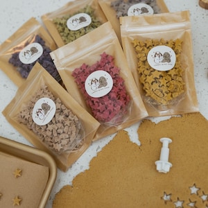 May include: A white ceramic mug with a black handle and the text "But First, Coffee" in a black, handwritten-style font. The mug is on a white surface.