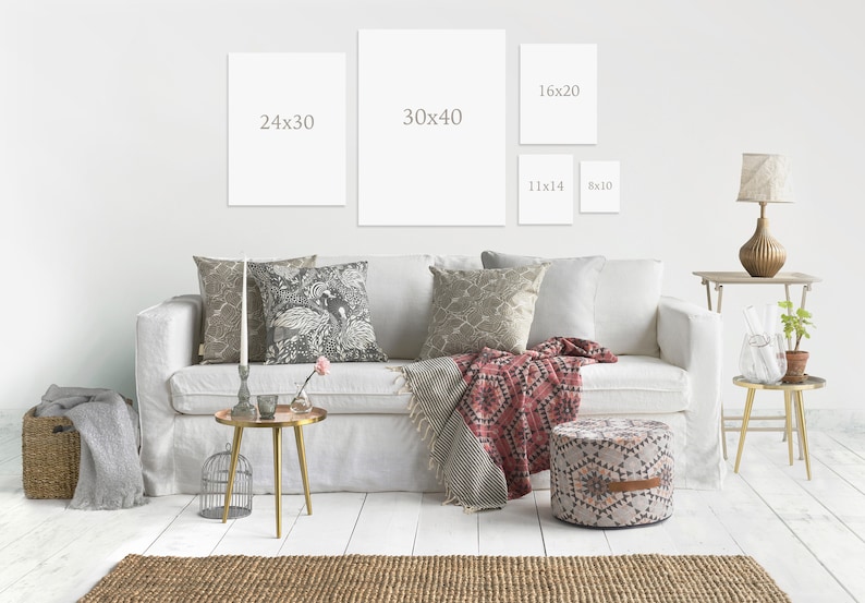 May include: A white sofa with pillows and a throw blanket in a living room setting. There are four framed pictures on the wall behind the sofa, with dimensions listed on each frame. The dimensions are 24x30, 30x40, 16x20, 11x14, and 8x10.