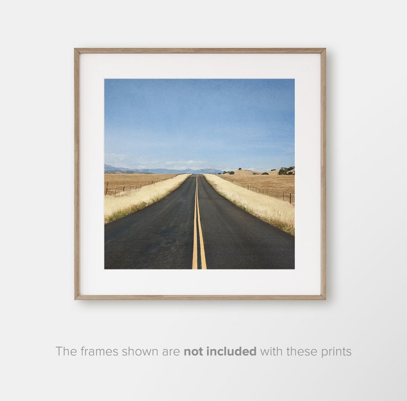 May include: A long, straight, paved road with yellow lines down the centre, leading to a distant horizon. The road is surrounded by dry, golden grass and a blue sky.
