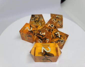 May include: A set of amber dice with a wasp trapped inside each die. The dice are numbered 1 through 7.