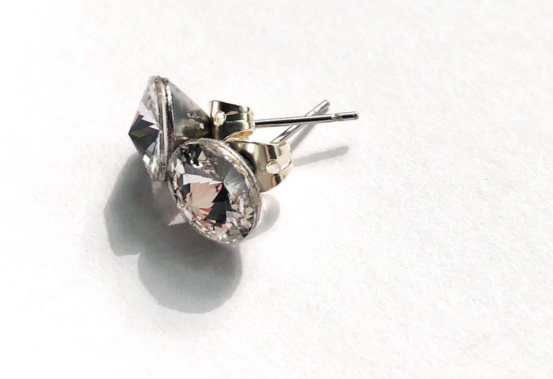 Peut inclure: Une paire de boucles d'oreilles en argent avec des pierres en cristal transparent. Les boucles d'oreilles ont un fermoir &agrave; tige et papillon.