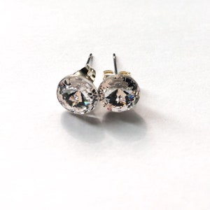 Peut inclure: Une paire de boucles d'oreilles clous en argent avec des pierres rondes en cristal transparent.