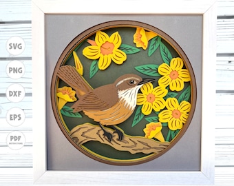 Puede incluir: Un pájaro marrón y naranja con flores amarillas y hojas verdes en un estilo de corte de papel. El pájaro está posado en una rama. La imagen está enmarcada en un marco blanco.