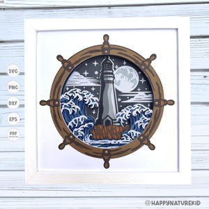 May include: A framed nautical-themed artwork featuring a lighthouse scene. The design includes a lighthouse, ocean waves, and a full moon, all within a ship's wheel frame. The artwork is in shades of blue, gray, and brown, with a white frame.